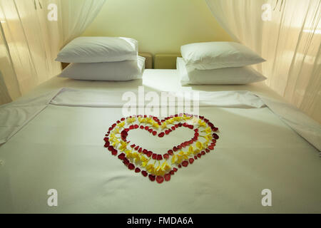 Hotel room with four-poster bed, heart of flowers, decorated double bed, Ubud, Bali, Indonesia Stock Photo