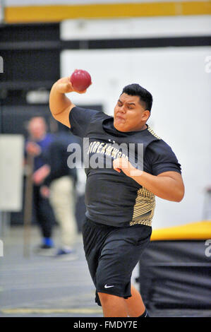 A high school athlete straining in throwing the shot put during an indoor track meet. USA. Stock Photo