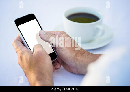 Casual businessman using smartphone and having coffee Stock Photo