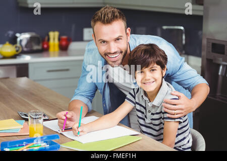 Portrait of father assisting boy in solving maths Stock Photo