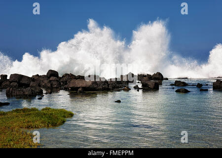 Waves crash against the lava shoreline and flood the tide pools at Wawaloli Beach on the Big Island of Hawaii. Stock Photo