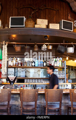 A bartender walks behind a restaurant bar in blurred motion. Stock Photo