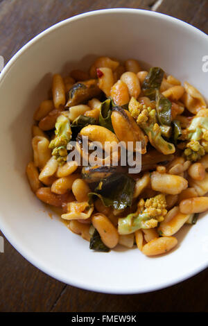 A bowl of white bean, romanesco and mussels soup shot from above.