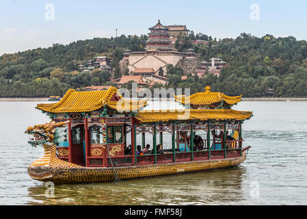 Tourists on a dragon boat floating on the Kunming Lake, Beijing, China. Summer Palace in the background. Stock Photo