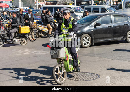 Chinese policeman patrol on motor scooters on a busy street in Beijing, China. Stock Photo