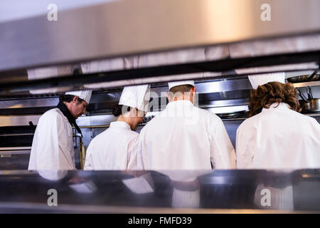 Group of chefs in white uniform busy to preparing food Stock Photo