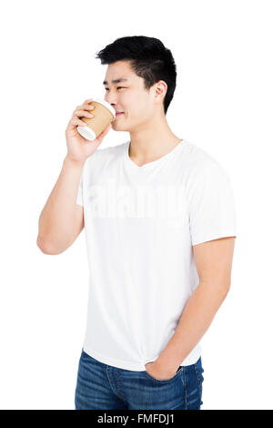 Young man drinking coffee from a disposable cup Stock Photo