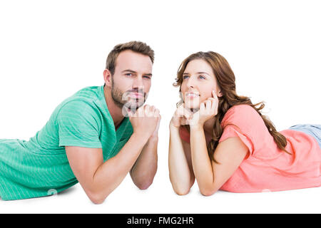 Thoughtful young couple lying on floor looking away Stock Photo