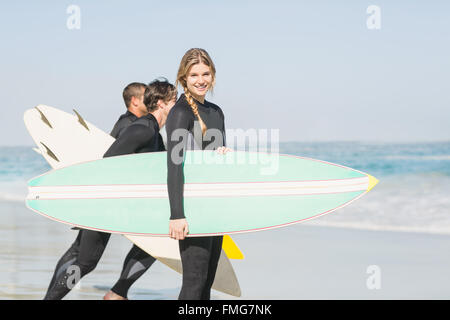 Portrait of surfer woman with surfboard standing on the beach Stock Photo