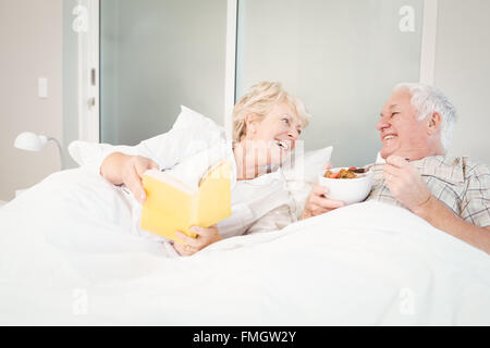 Senior couple reading book in bed Stock Photo