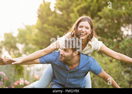 Happy man carrying woman on back Stock Photo