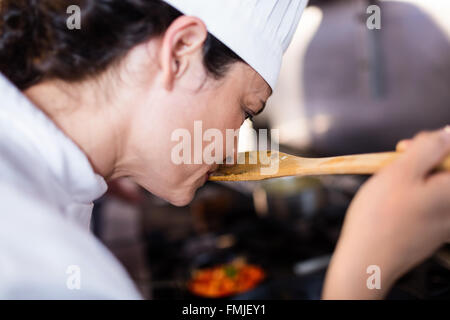 Chef smelling food in the kitchen Stock Photo