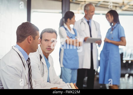 Two doctors with clipboard and discussing Stock Photo