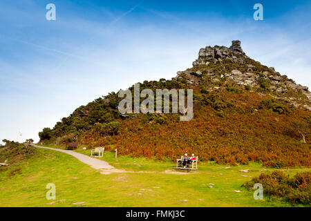 Two walkers resting on a bench in the Valley of Rocks, nr Lynton, North Devon, England, UK Stock Photo