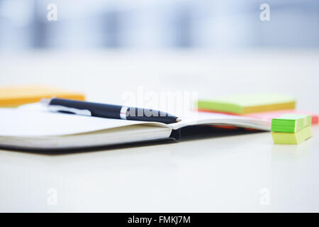 Ballpoint pen on the notepad and adhesive notes in the office Stock Photo