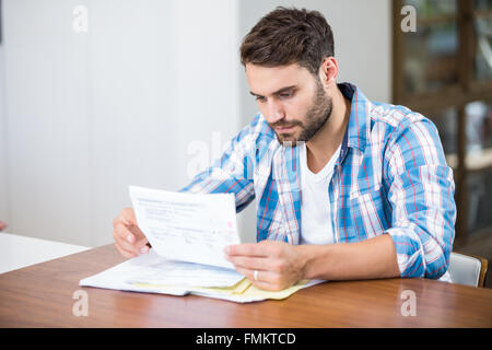 Man reading documents while sitting at table Stock Photo