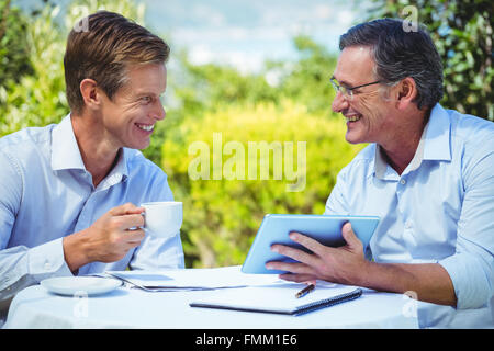 Two businessmen meeting in a restaurant using tablet Stock Photo