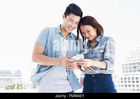 Happy young couple using mobile phone Stock Photo