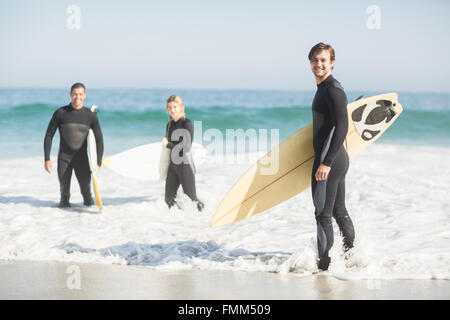 Portrait of surfer friends with surfboard standing on the beach Stock Photo
