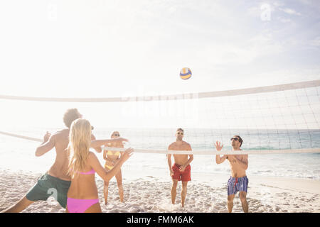 Happy friends playing beach volleyball Stock Photo