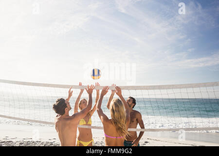 Happy friends playing beach volleyball Stock Photo