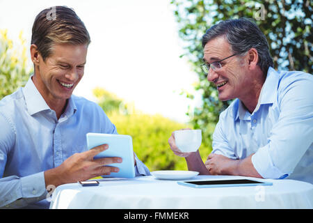Two businessmen meeting in a restaurant using tablet Stock Photo