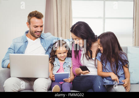 Family using modern technologies on sofa Stock Photo