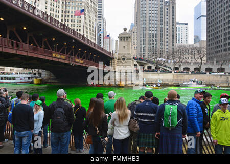 People watch from the bank as the Plumbers Union dyes the Chicago River green for St. Patrick's Day on March 12, 2016. Stock Photo