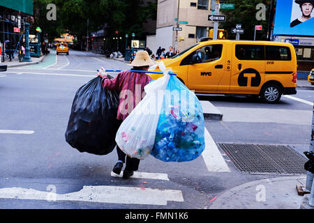 NEW YORK CITY - OCTOBER 7, 2014: Person collecting a lot of bottles and cans, in  Manhattan, on Lafayette and Bleecker Stock Photo
