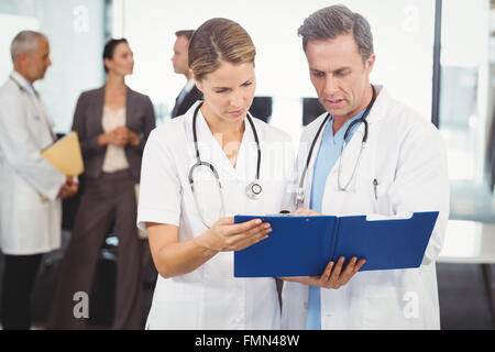 Two doctors looking at clipboard and discussing Stock Photo