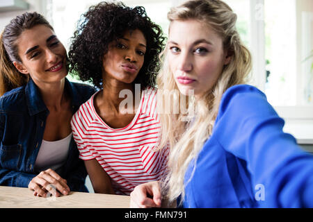 Portrait of beautiful young female friends puckering lips Stock Photo