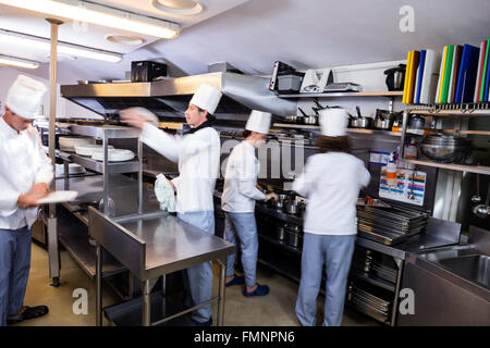 Team of chefs preparing food in the kitchen Stock Photo