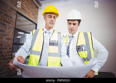 Architects working while holding blueprint Stock Photo