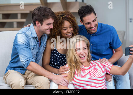 Cheerful young friends taking selfie at home Stock Photo