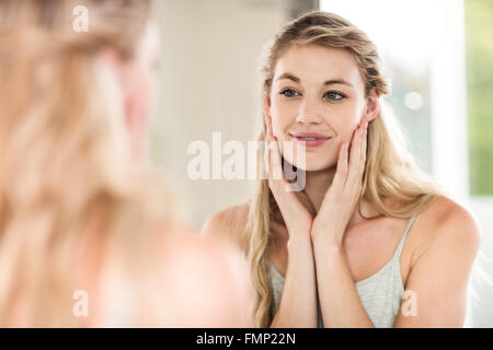 Happy young woman looking in mirror Stock Photo