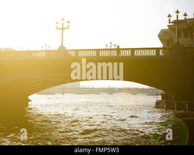 Commuters walking across Blackfriar's Bridge at dusk with the sun setting Stock Photo