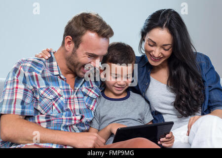 Mother, father and son looking at digital tablet Stock Photo