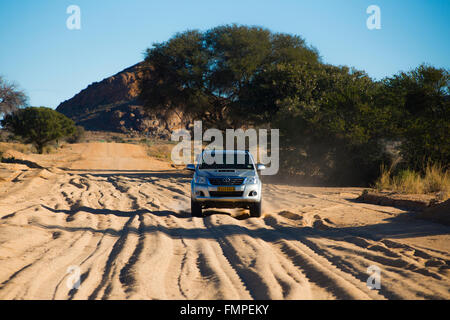 SUV driving on sandy road in south, Keetmanshoop, Karas Region, Namibia Stock Photo