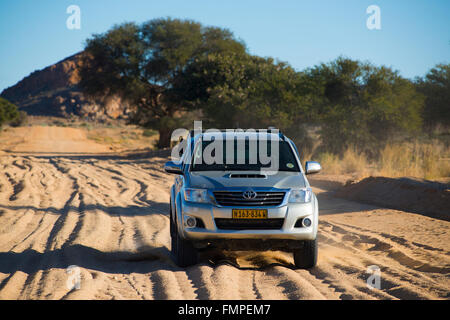 SUV driving on sandy road in south, Keetmanshoop, Karas Region, Namibia Stock Photo