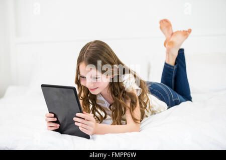 Girl using digital tablet on bed Stock Photo