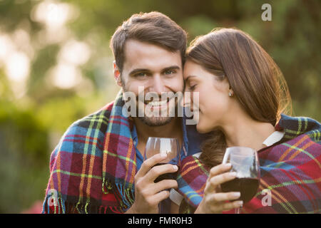 Young couple with wine wrapped in blanket Stock Photo