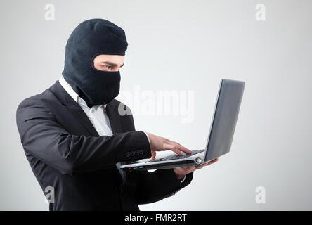 Portrait of a hacker with balaclava against grey background Stock Photo