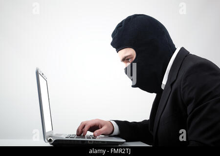 Portrait of a hacker with balaclava against grey background Stock Photo