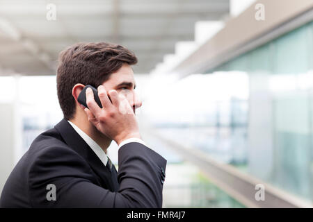 Profile view of a handsome young business man talking on cell phone Stock Photo