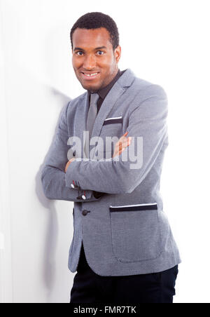 Confident young business man leaning against the wall Stock Photo