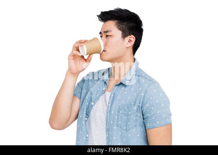 Young man drinking coffee from a disposable cup Stock Photo
