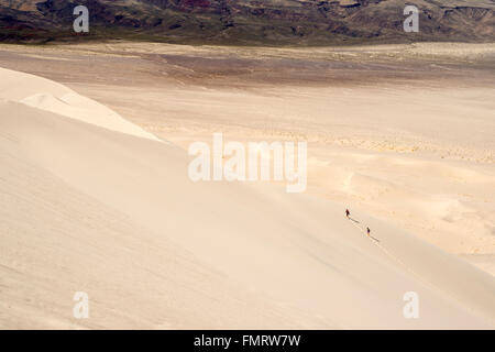 Two people hiking on the Eureka Valley sand dunes in Death Valley National Park, California Stock Photo