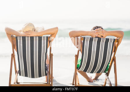 Rear view of couple relaxing on the beach Stock Photo