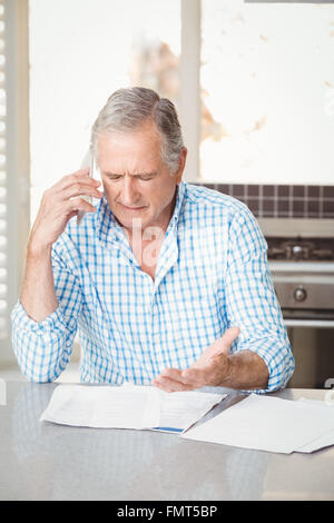 Serious senior man talking on mobile phone Stock Photo