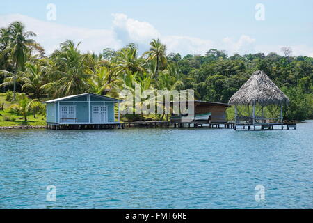 Tropical shore with small house and thatched hut over the water in Bocas del Toro, Caribbean coast of Panama, Central America Stock Photo